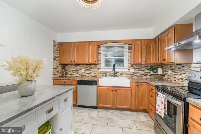 a kitchen with stainless steel appliances granite countertop a sink stove and cabinets