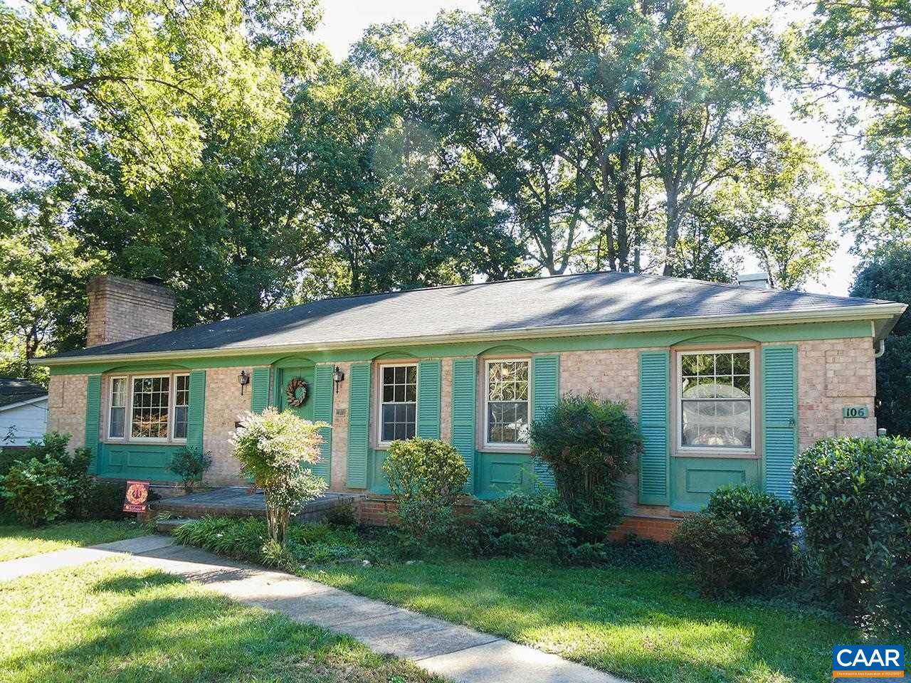 a view of a house with a yard and potted plants