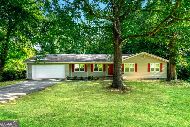 a front view of a house with yard and green space