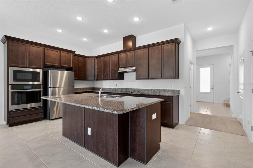 810 MIDDLETON Street DeBary, FL 32713 - Photo 7 of 52 a kitchen with kitchen island granite countertop a sink stove and refrigerator