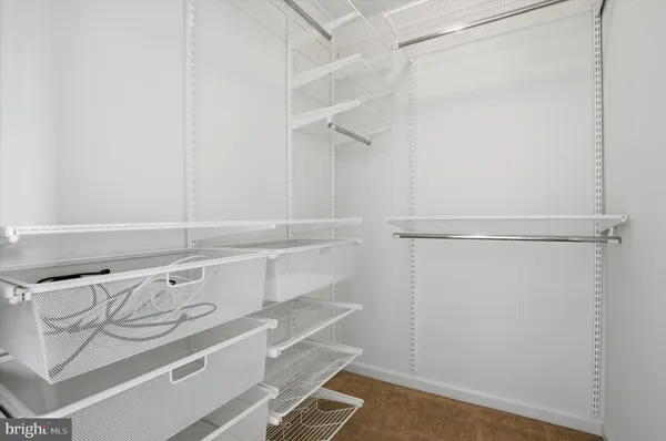 a view of walk in closet with empty racks