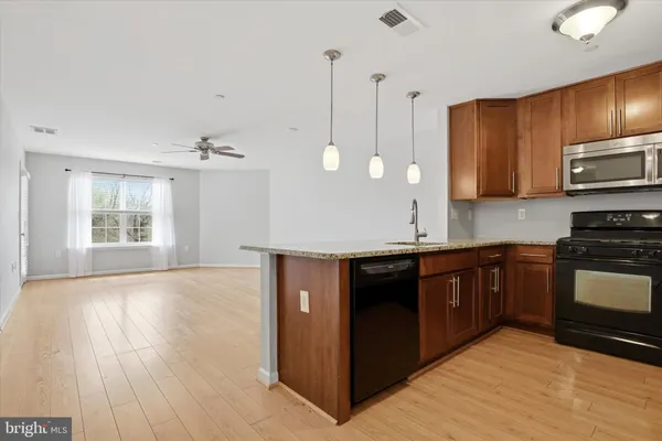 a kitchen with stainless steel appliances granite countertop a stove a sink and a microwave