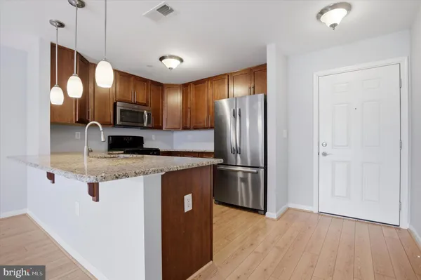 a kitchen with stainless steel appliances granite countertop a refrigerator a stove top oven a sink and dishwasher