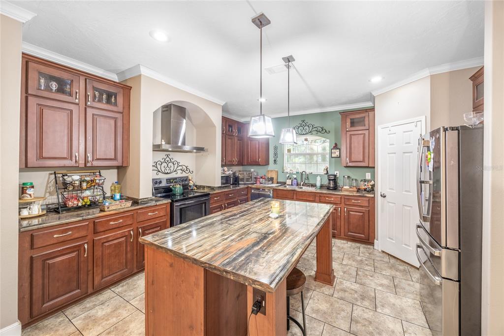 1085 State Rte 100 Florahome, FL 32140 - Photo 13 of 52 a kitchen with stainless steel appliances granite countertop a refrigerator a sink dishwasher a stove and white cabinets with wooden floor