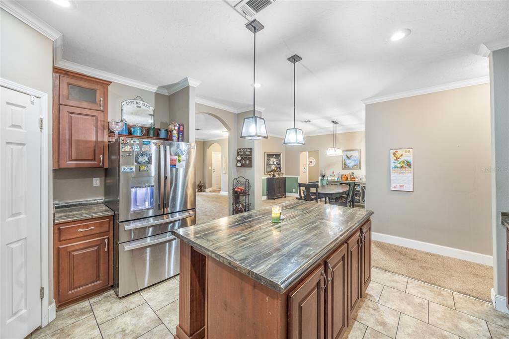 1085 State Rte 100 Florahome, FL 32140 - Photo 15 of 52 a kitchen with stainless steel appliances kitchen island granite countertop a table chairs and stove