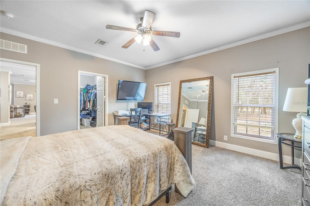 1085 State Rte 100 Florahome, FL 32140 - Photo 21 of 52 a spacious bedroom with a large bed a chandelier and windows