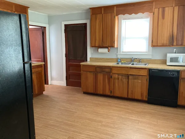 a large kitchen with stainless steel appliances granite countertop a refrigerator and a sink