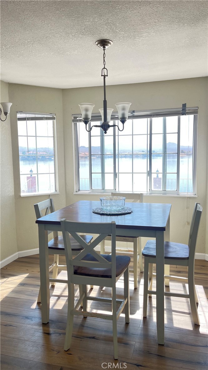 14515 Rivers Edge Road Helendale, CA 92342 - Photo 18 of 24 a dining room with wooden floor a chandelier a wooden table and chairs