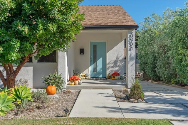 a front view of a house with a tree