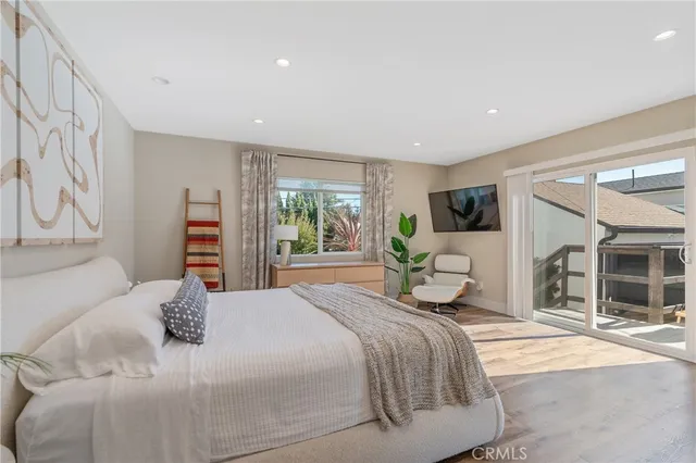 a bedroom with a large bed and a flat tv screen