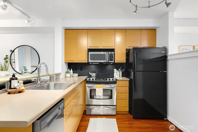 a kitchen with a sink a refrigerator and a stove top oven