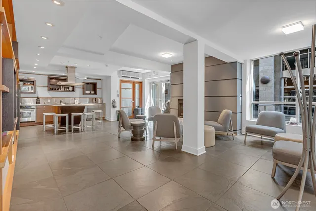 a living room with couches and kitchen view with wooden floor