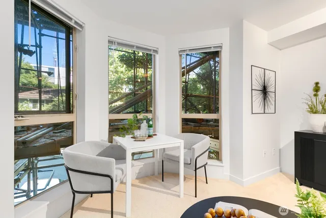 a view of a dining room with furniture large windows and wooden floor