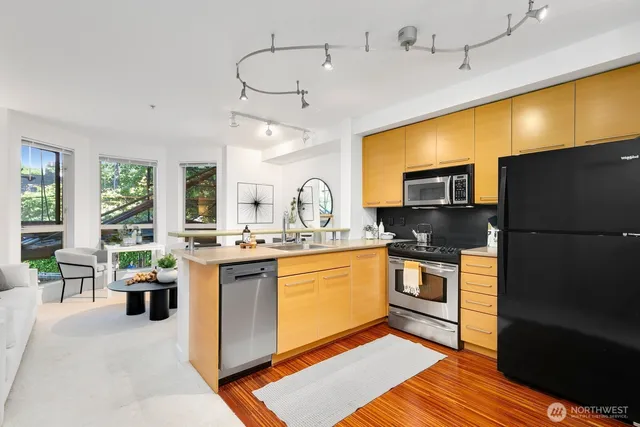 a kitchen with stainless steel appliances granite countertop a sink a stove and refrigerator