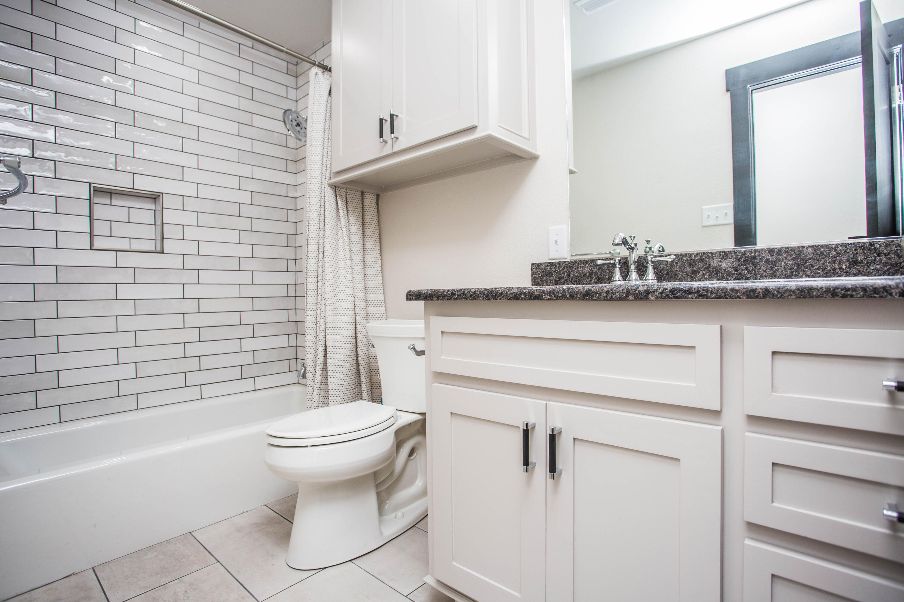 25 East Lakeshore Drive Ransom Canyon, TX 79366 - Photo 26 of 63 a bathroom with a granite countertop sink a toilet and bathtub