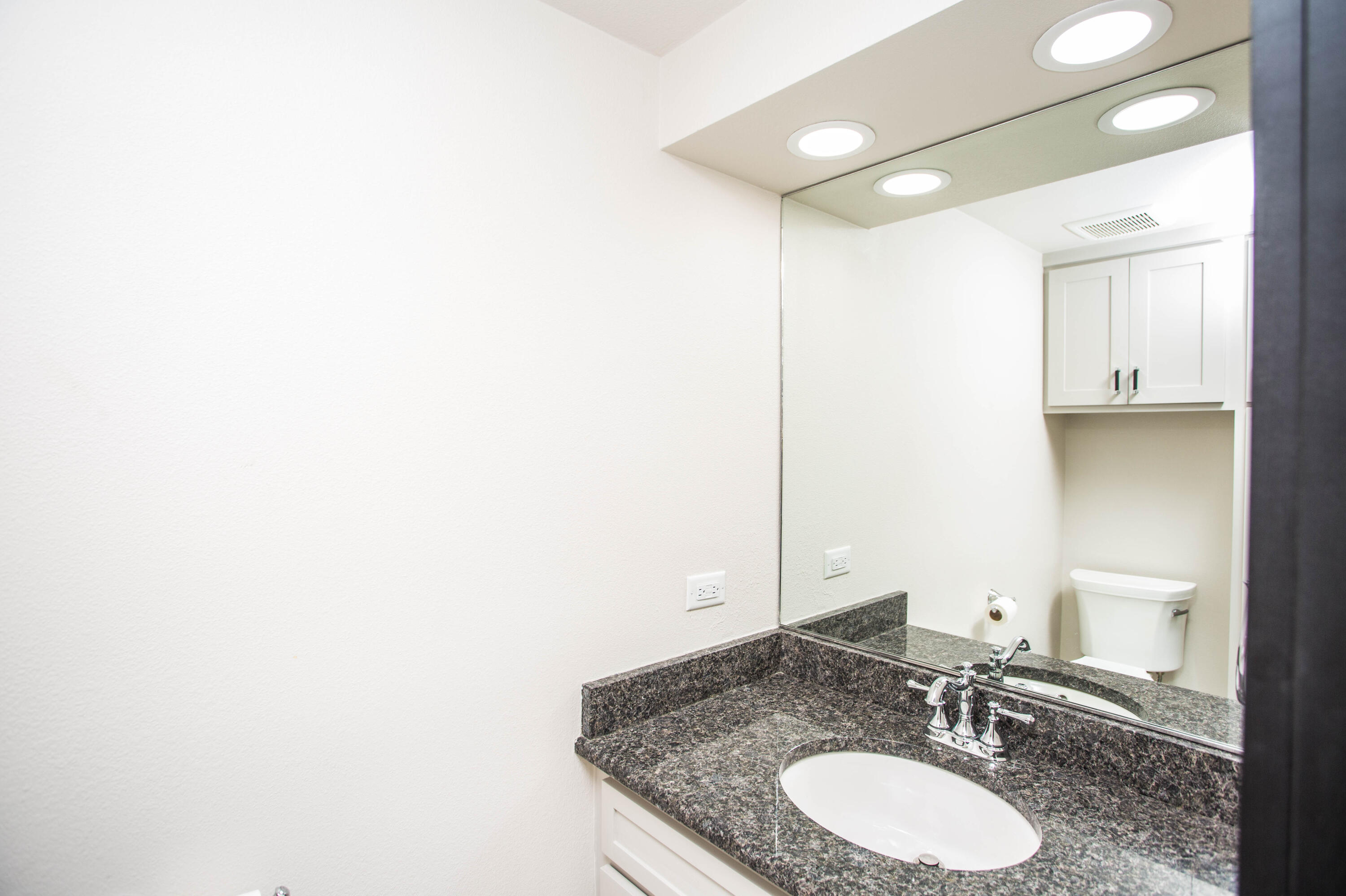 25 East Lakeshore Drive Ransom Canyon, TX 79366 - Photo 33 of 63 a bathroom with a granite countertop sink and a mirror