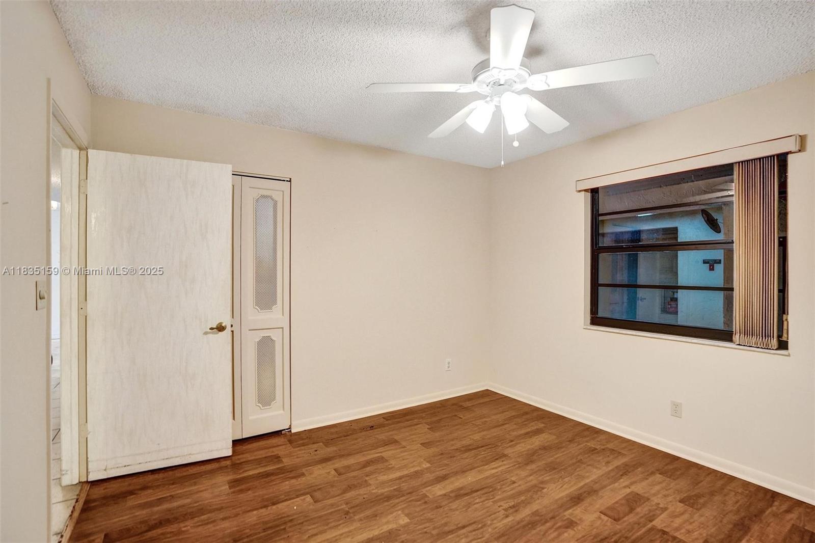 4965 East Sabal Palm Boulevard, Unit 207 Tamarac, FL 33319 - Photo 13 of 37 wooden floor in an empty room with a window