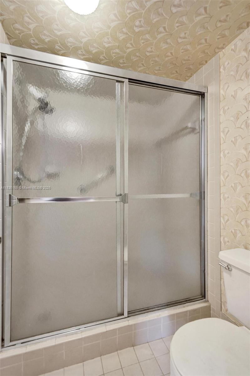 4965 East Sabal Palm Boulevard, Unit 207 Tamarac, FL 33319 - Photo 22 of 37 a bathroom with a glass shower door