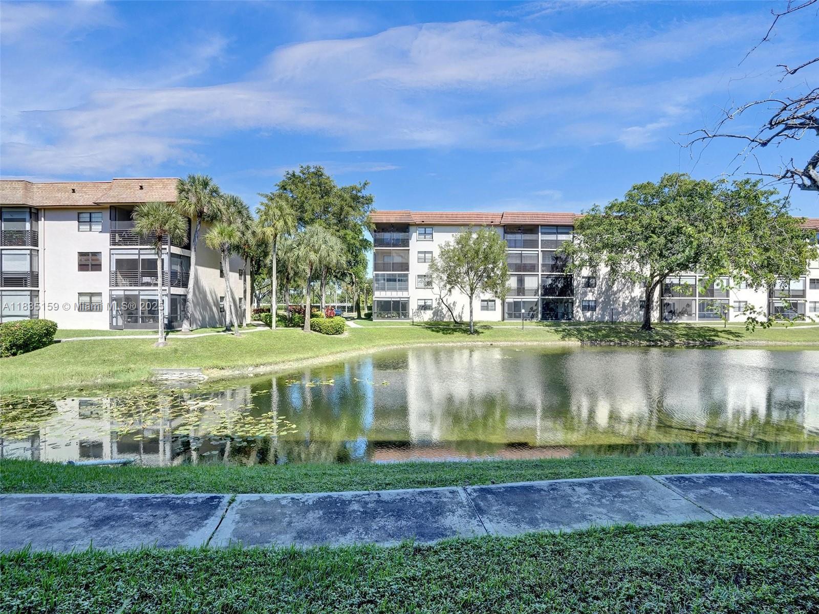 4965 East Sabal Palm Boulevard, Unit 207 Tamarac, FL 33319 - Photo 29 of 37 a view of a lake with a building in the background