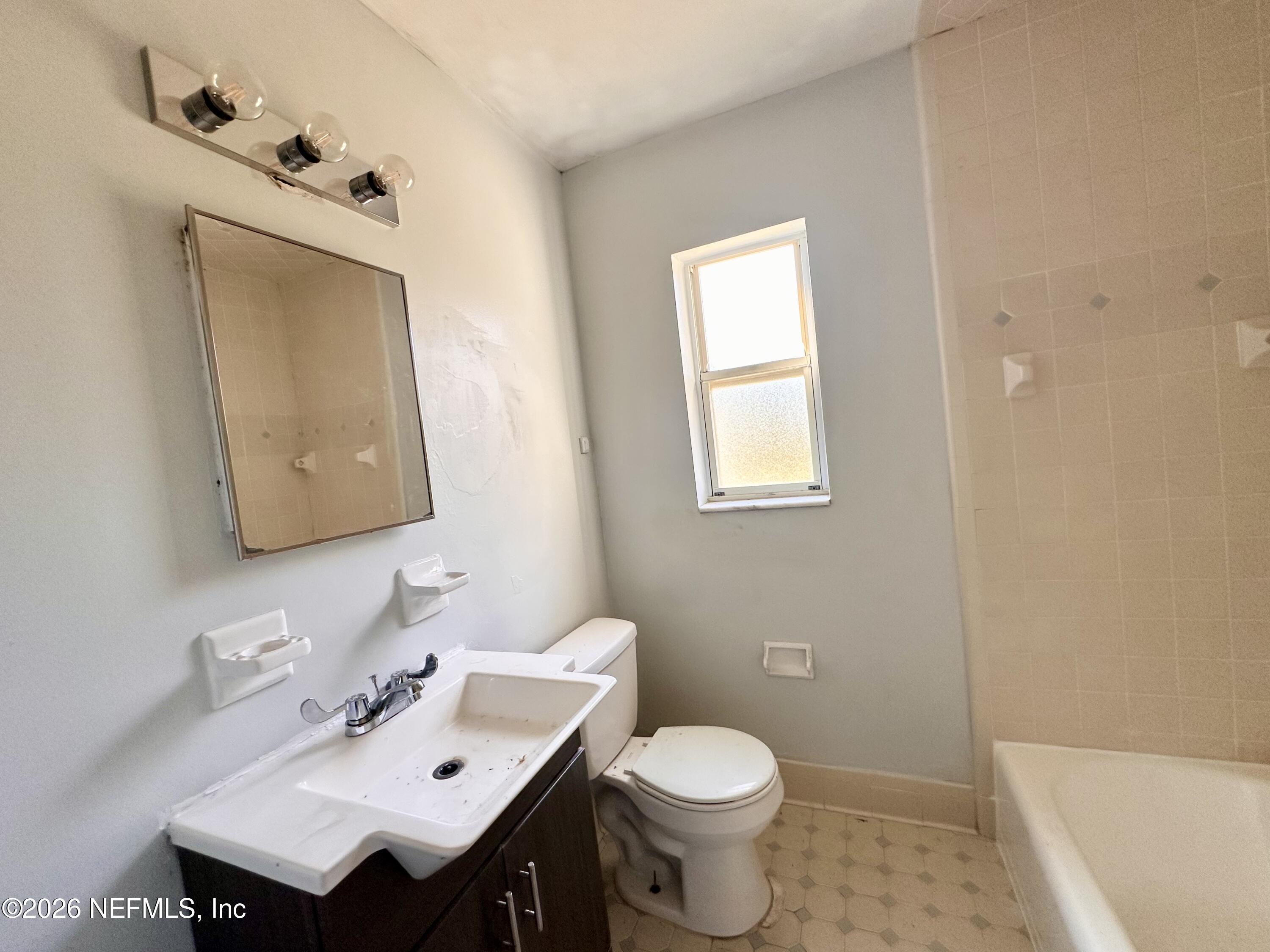 3638 Jammes Road Jacksonville, FL 32210 - Photo 15 of 31 a bathroom with a toilet sink vanity and mirror