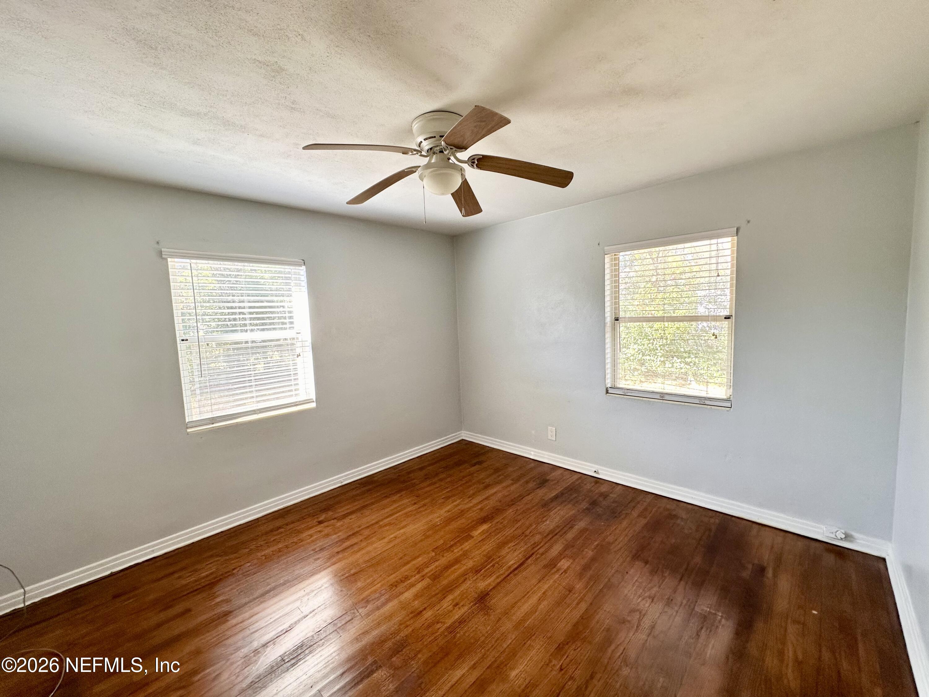 3638 Jammes Road Jacksonville, FL 32210 - Photo 17 of 31 a view of an empty room with wooden floor and a window