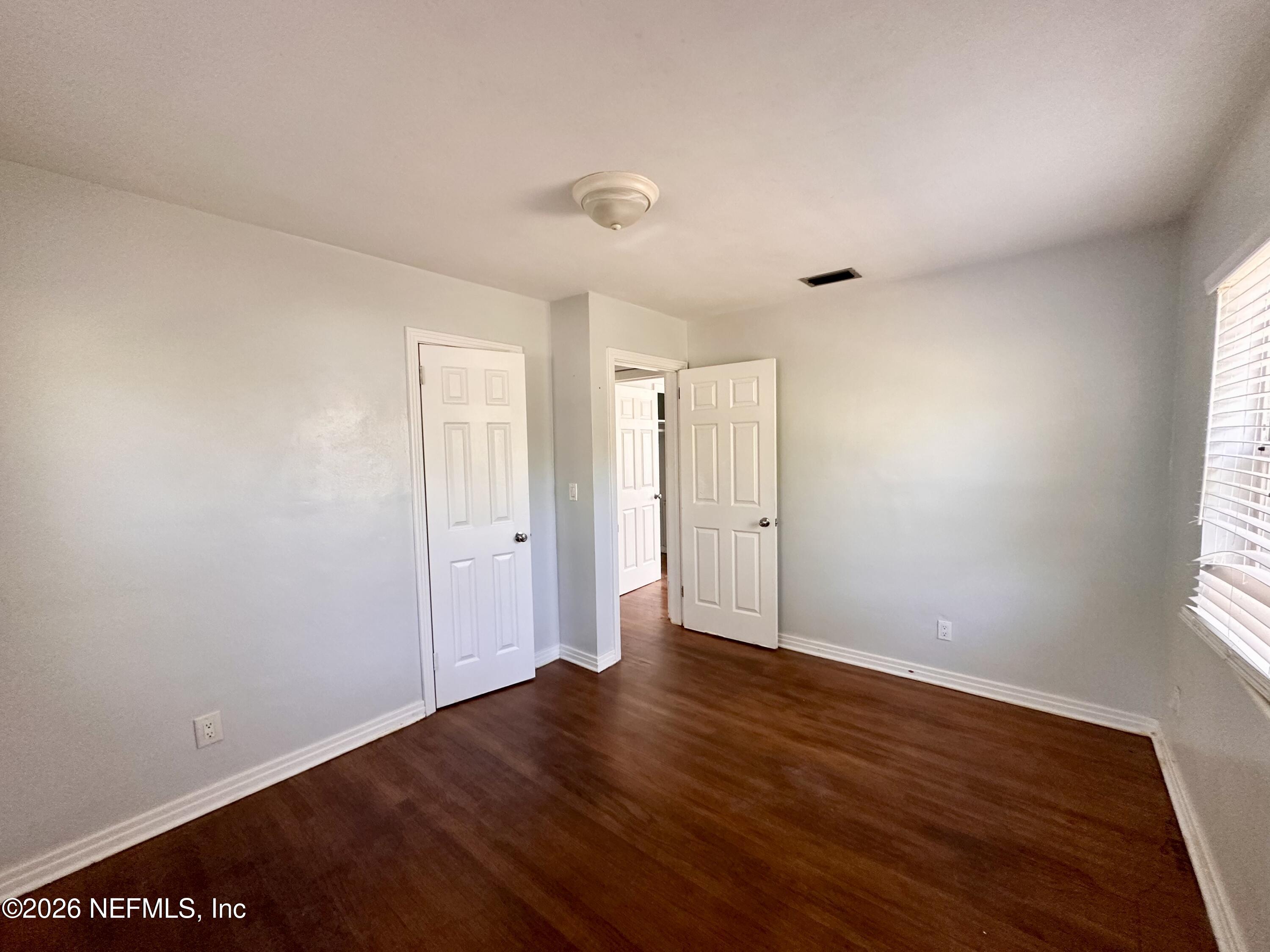 3638 Jammes Road Jacksonville, FL 32210 - Photo 23 of 31 a view of an empty room with wooden floor and a window
