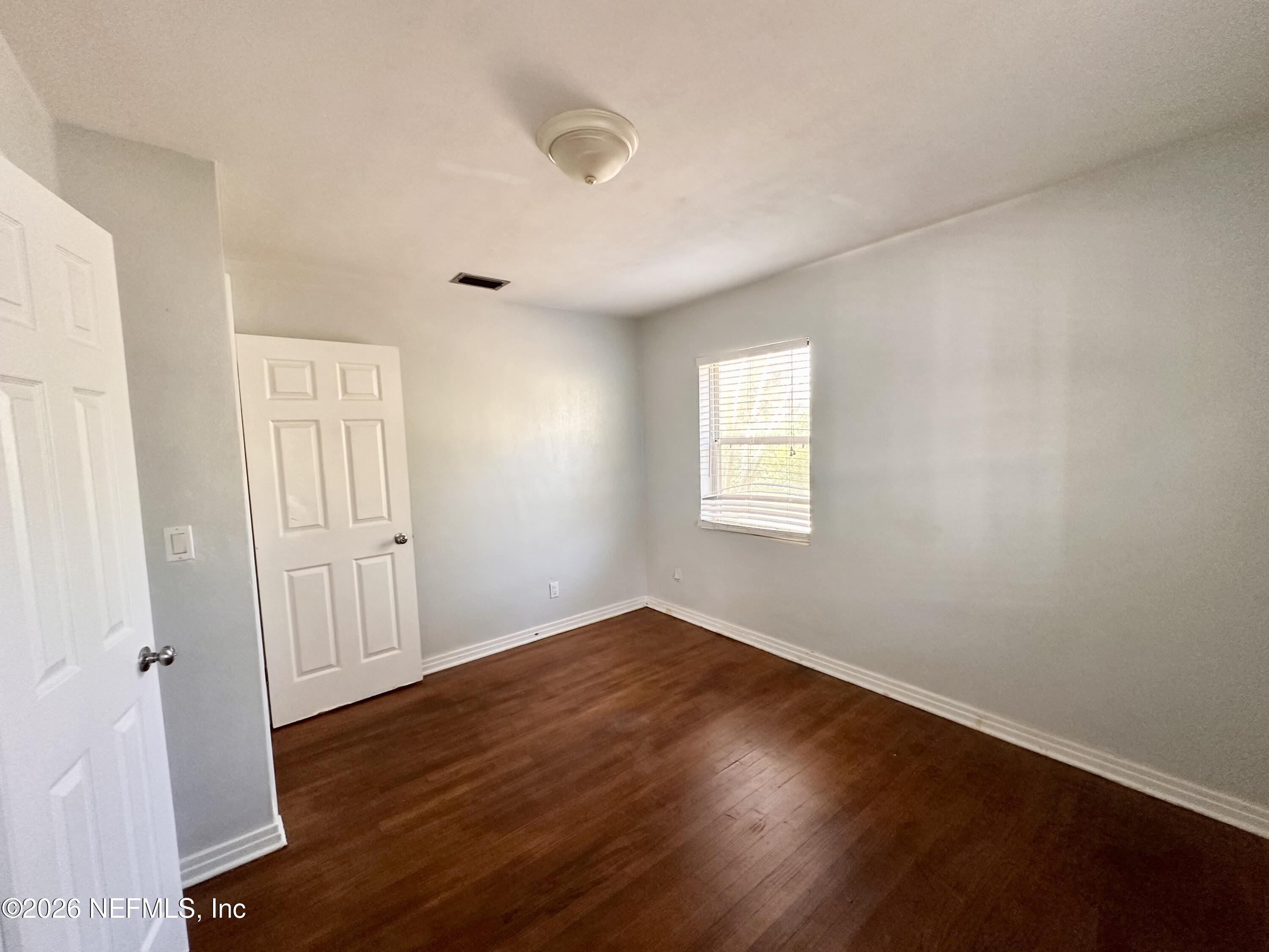 3638 Jammes Road Jacksonville, FL 32210 - Photo 24 of 31 an empty room with wooden floor and windows