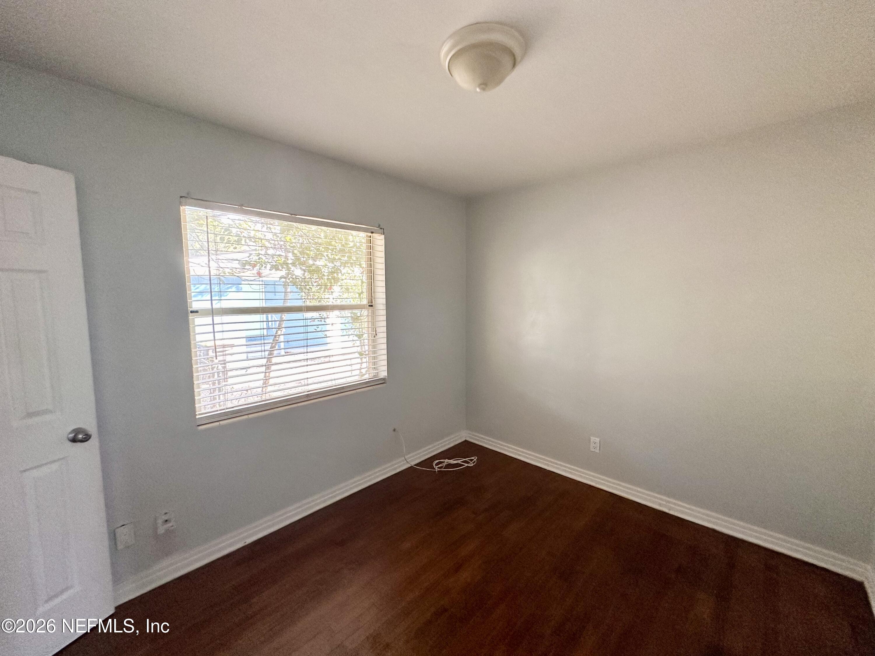 3638 Jammes Road Jacksonville, FL 32210 - Photo 25 of 31 an empty room with wooden floor and windows
