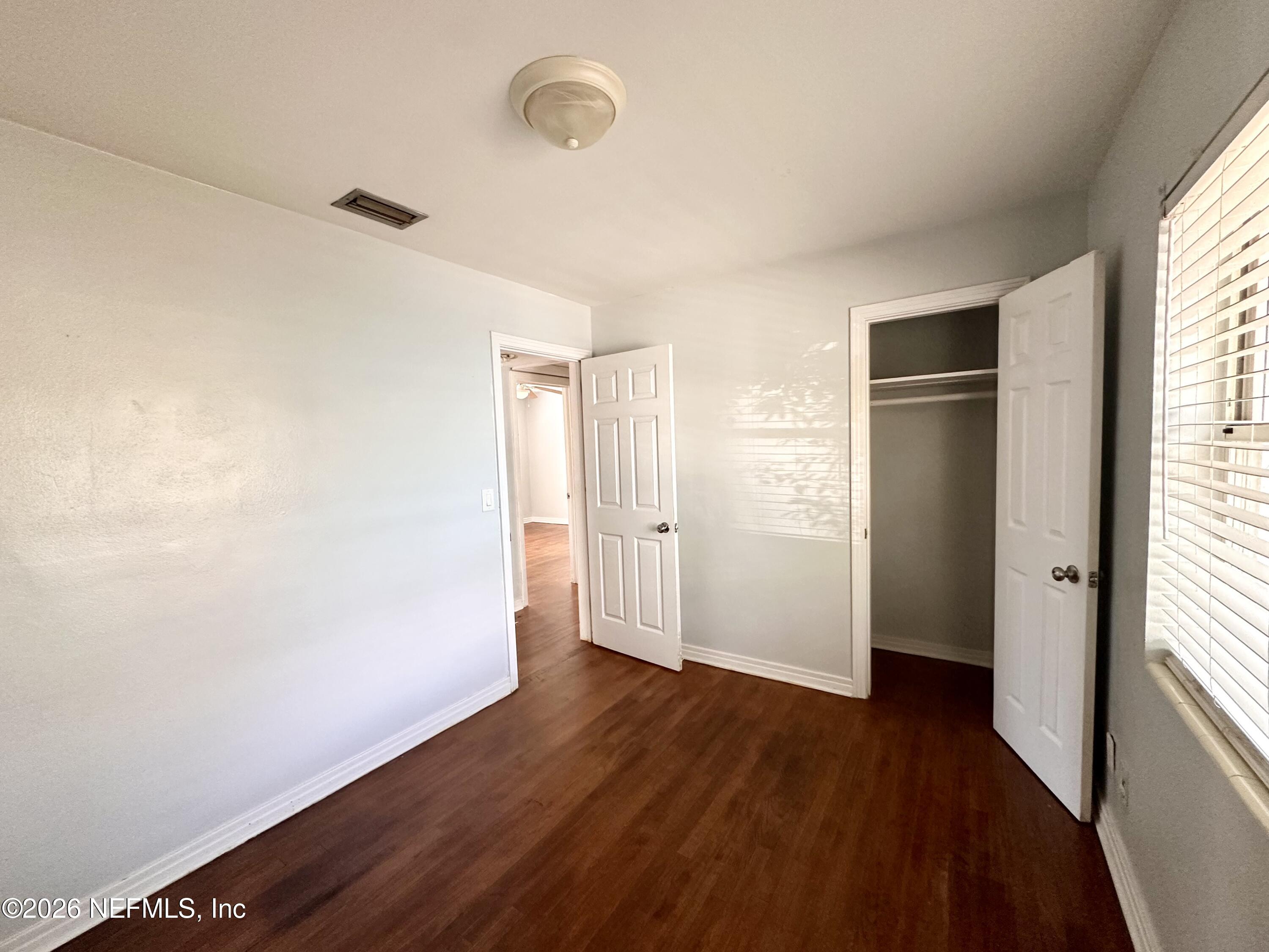 3638 Jammes Road Jacksonville, FL 32210 - Photo 27 of 31 an empty room with wooden floor and windows