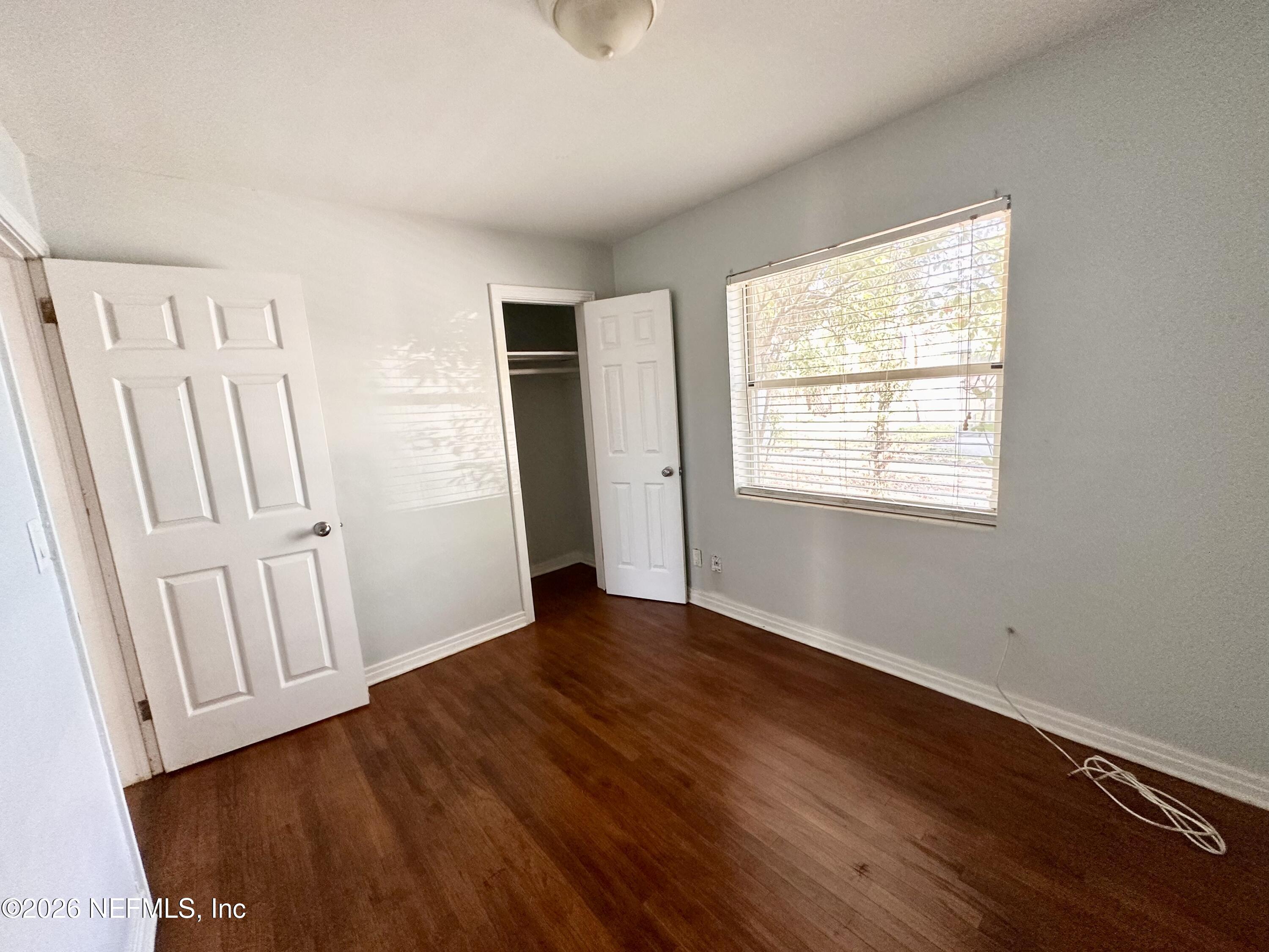 3638 Jammes Road Jacksonville, FL 32210 - Photo 28 of 31 a view of an empty room with wooden floor and a window