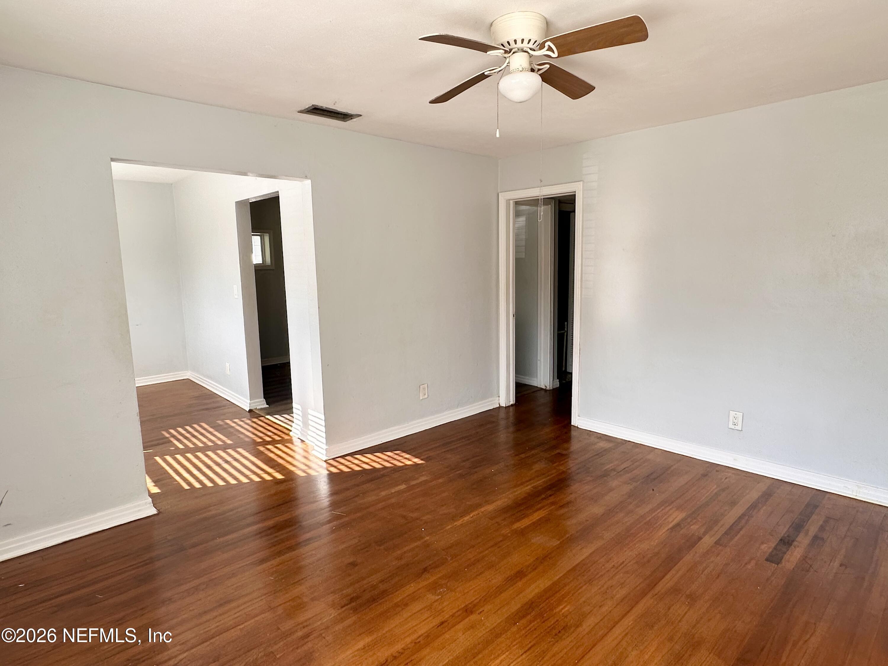 3638 Jammes Road Jacksonville, FL 32210 - Photo 6 of 31 an empty room with wooden floor closet and windows