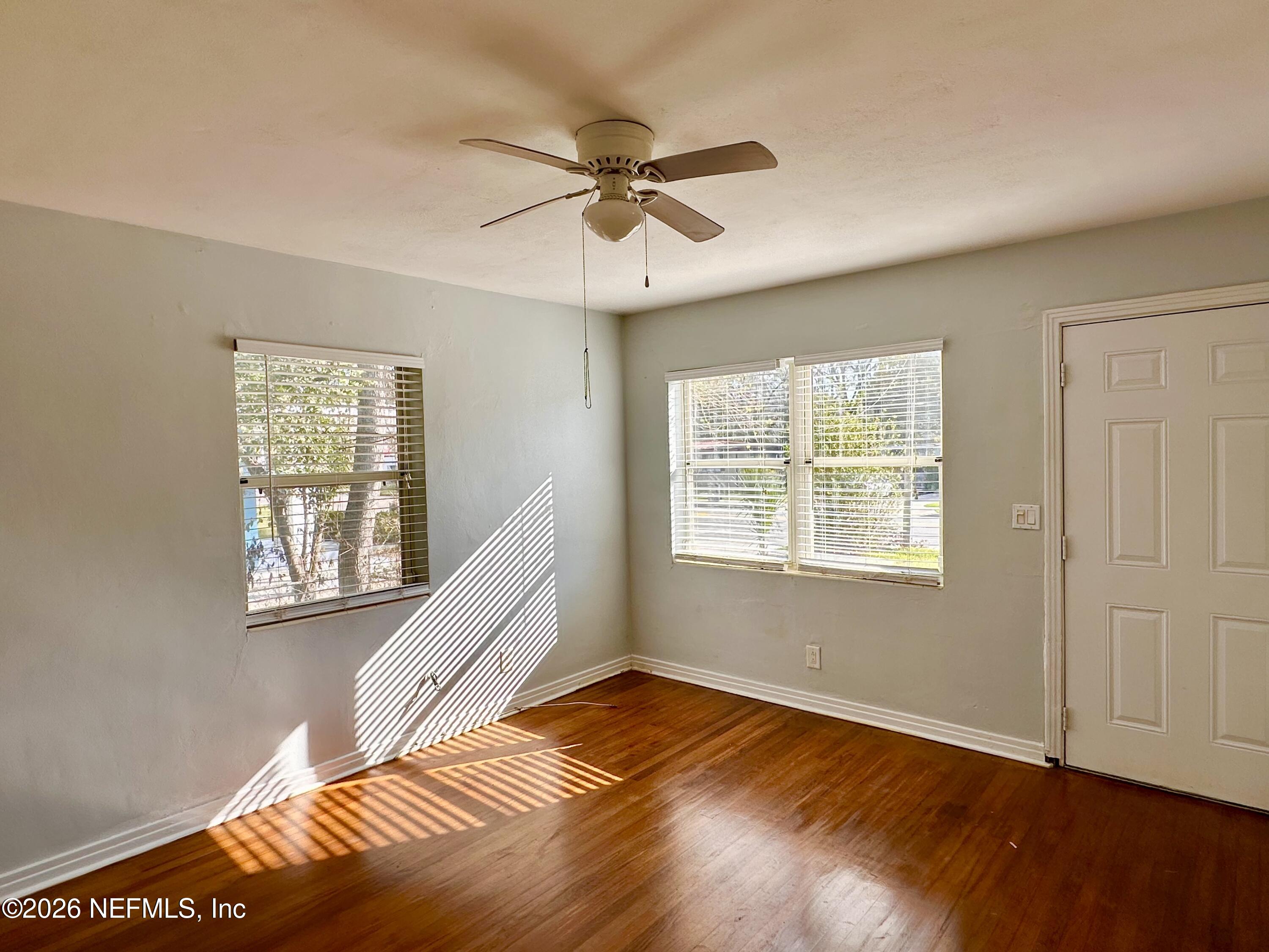 3638 Jammes Road Jacksonville, FL 32210 - Photo 7 of 31 a view of an empty room with wooden floor and a window