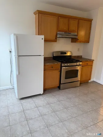 a kitchen with granite countertop a refrigerator a stove a microwave and cabinets