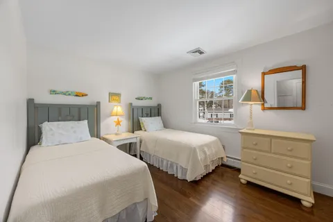 a bedroom with two beds and painting on the wall