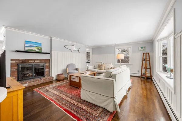 a dining room with wooden floor and a chandelier