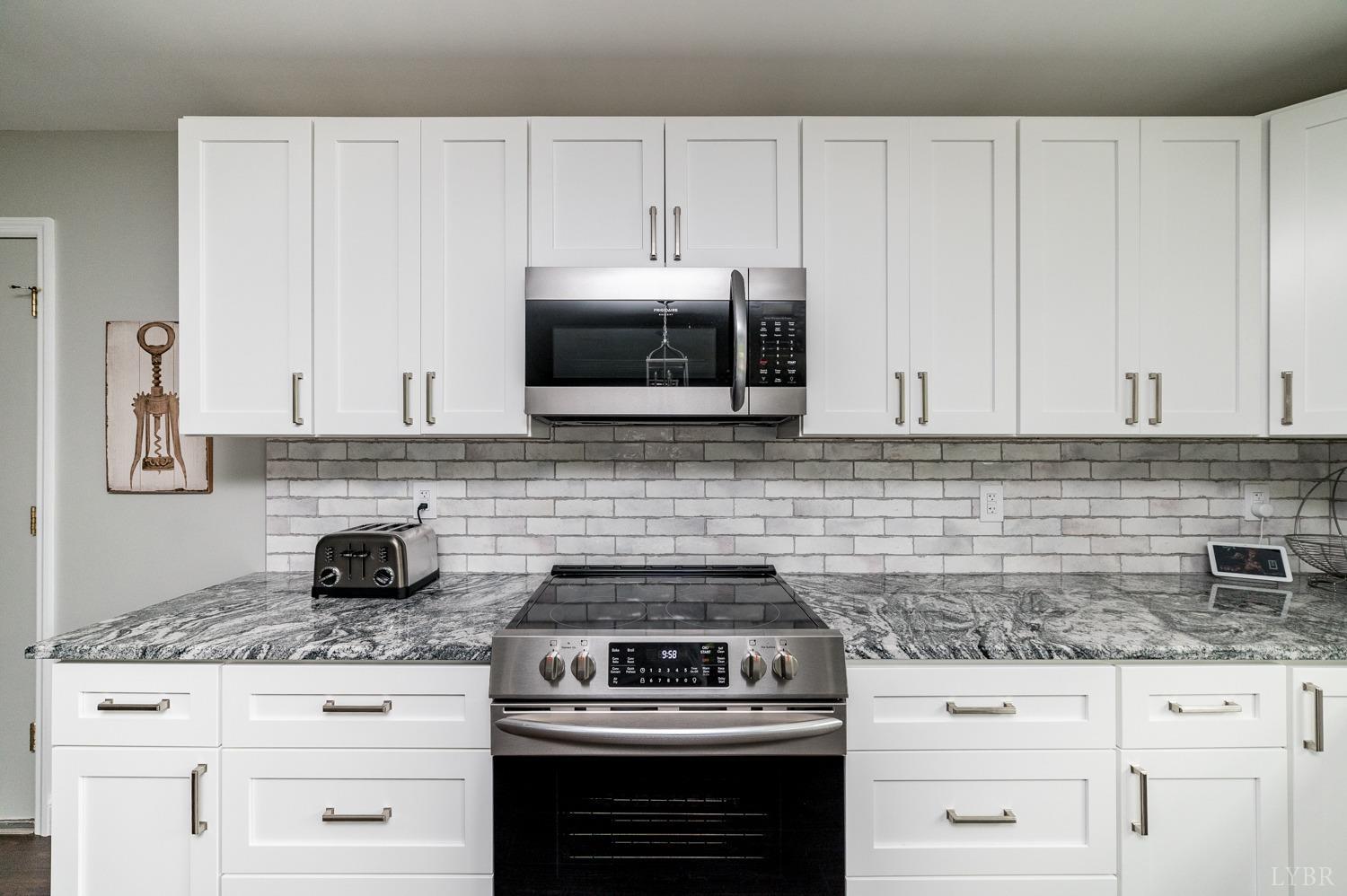 5335 Perrowville Road Forest, VA 24551 - Photo 25 of 65 a kitchen with granite countertop white cabinets and appliances