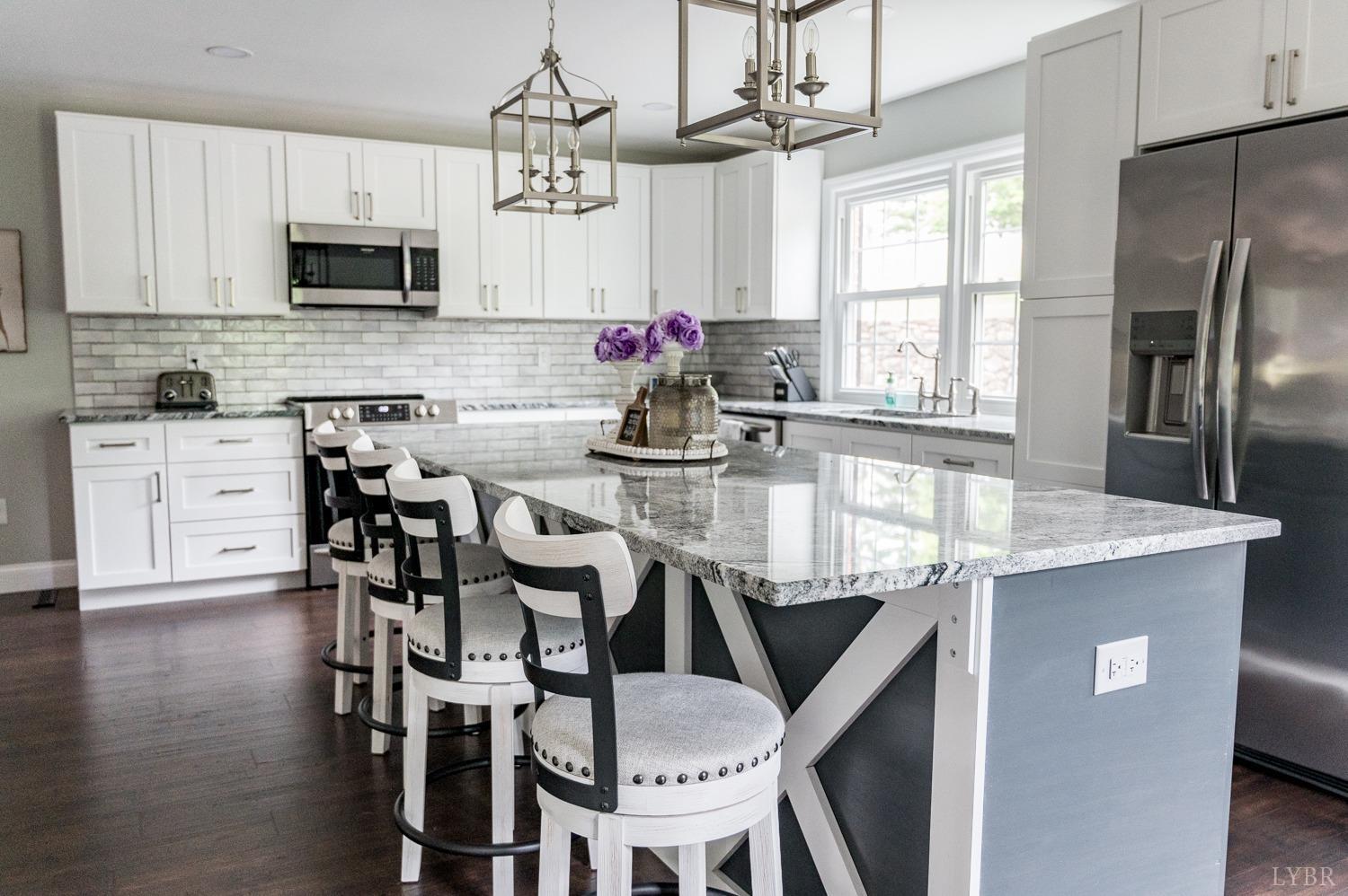 5335 Perrowville Road Forest, VA 24551 - Photo 31 of 65 a kitchen with stainless steel appliances granite countertop a dining table chairs refrigerator and microwave