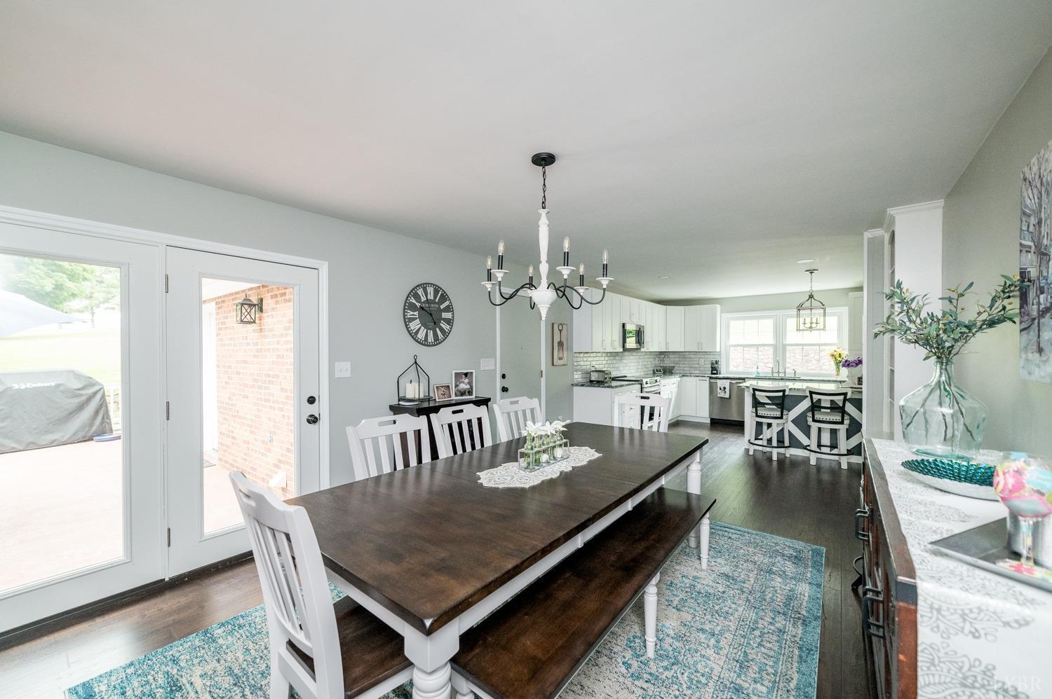 5335 Perrowville Road Forest, VA 24551 - Photo 35 of 65 a dining room with wooden floor a chandelier a wooden table and chairs