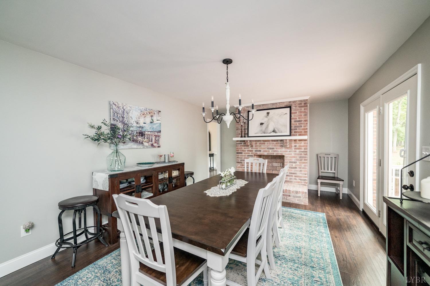 5335 Perrowville Road Forest, VA 24551 - Photo 36 of 65 a view of a dining room with furniture a chandelier and wooden floor