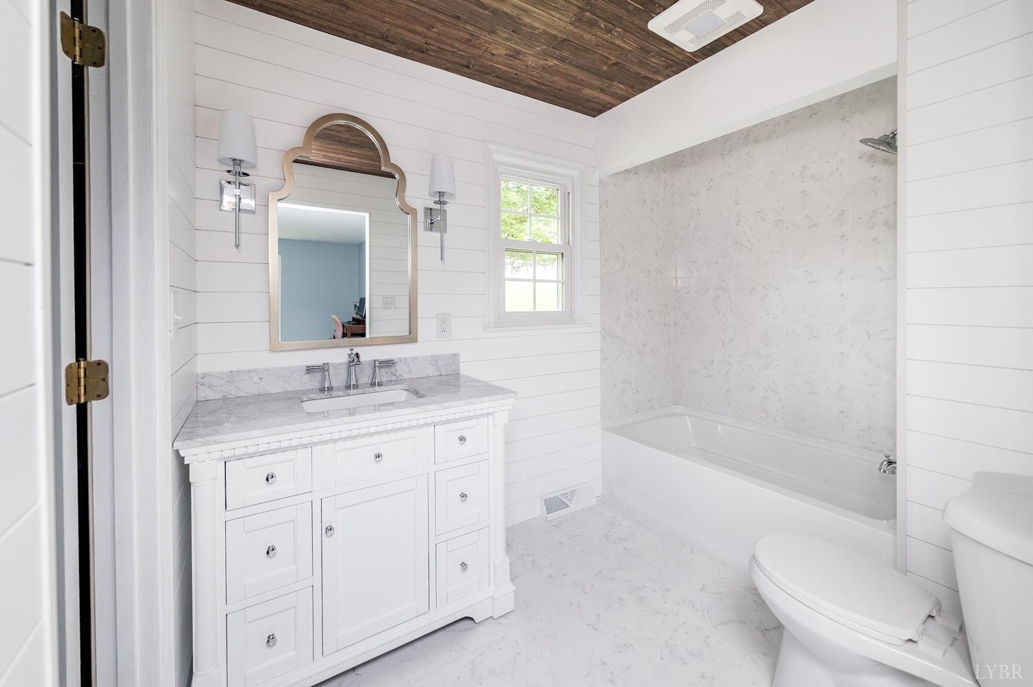 5335 Perrowville Road Forest, VA 24551 - Photo 49 of 65 a bathroom with a granite countertop sink a toilet and bathtub