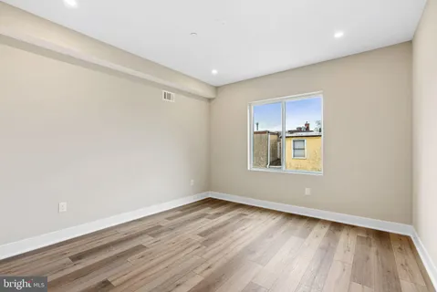 a room with a wooden floor and a window