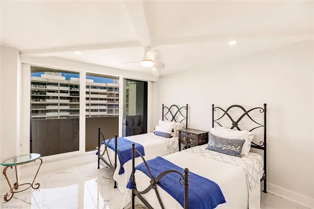 a bedroom with furniture and a large window