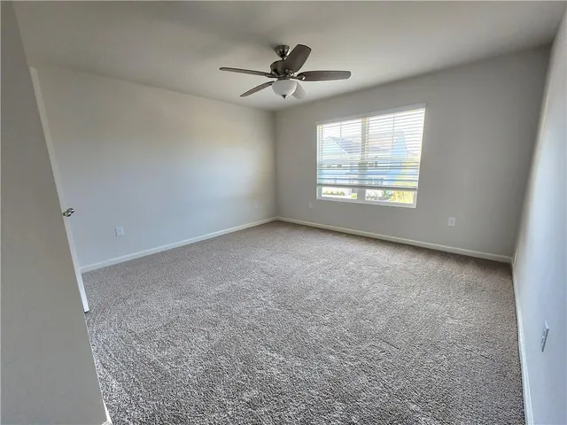 a view of a livingroom with a ceiling fan and window