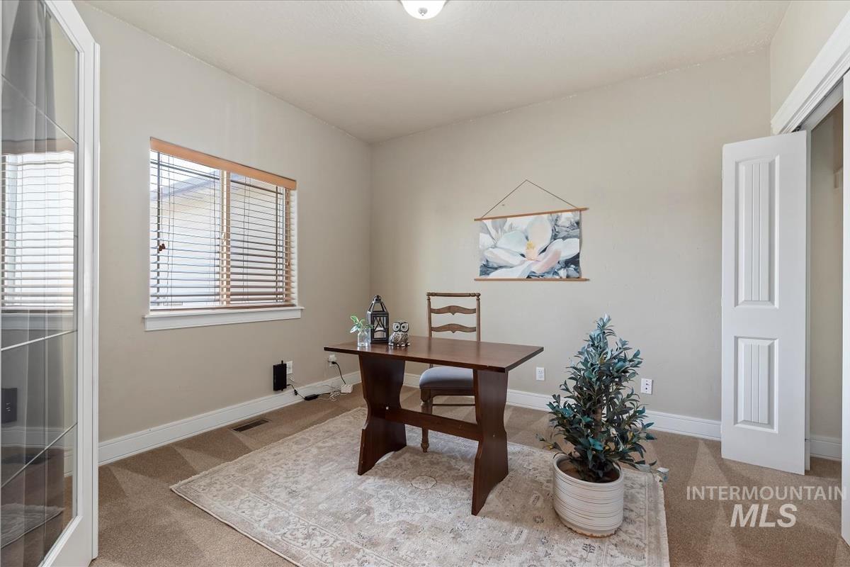 640 Southwest Miner Street Mountain Home, ID 83647 - Photo 5 of 35 Room featuring neutral-toned carpet, a window with wood-finish blinds, and a white paneled door