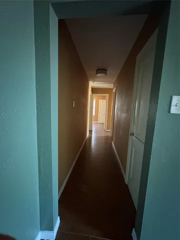 en empty room with wooden floor fan and windows