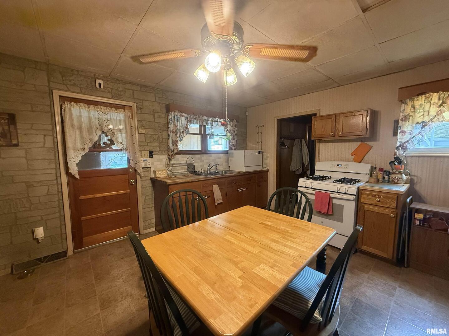401 North 23rd Street Herrin, IL 62948 - Photo 3 of 23 a kitchen with stainless steel appliances kitchen island granite countertop a table chairs in it and wooden floors
