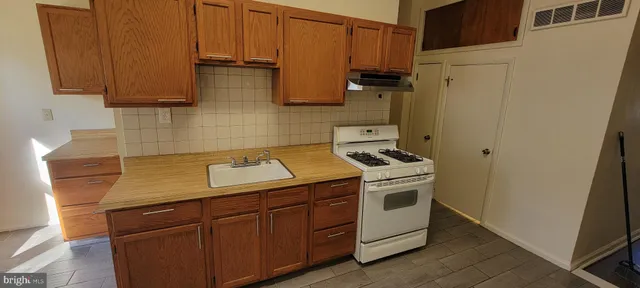 a kitchen with stainless steel appliances wooden cabinets and a stove top oven