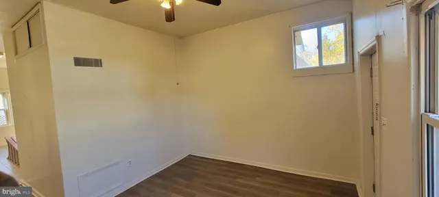 a view of a small space with wooden floor and a window