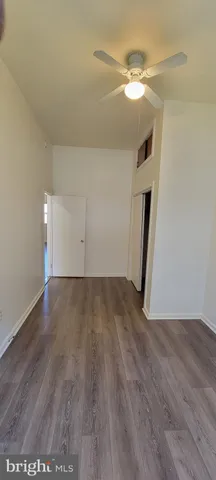 an empty room with wooden floor and window