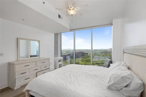 a bedroom with a large bed and a chandelier